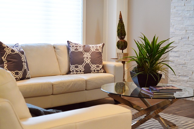 modern living room with neutral sofa, textured rug, and soft green decor accents